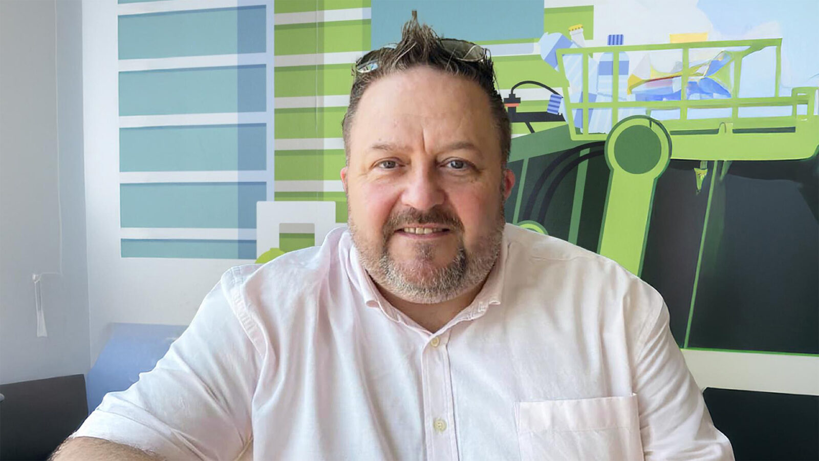 Endurance Vehicle Solutions Group Sales Director, Stewart Gregory is pictured against a illustrated wallpaper of refuse collection.