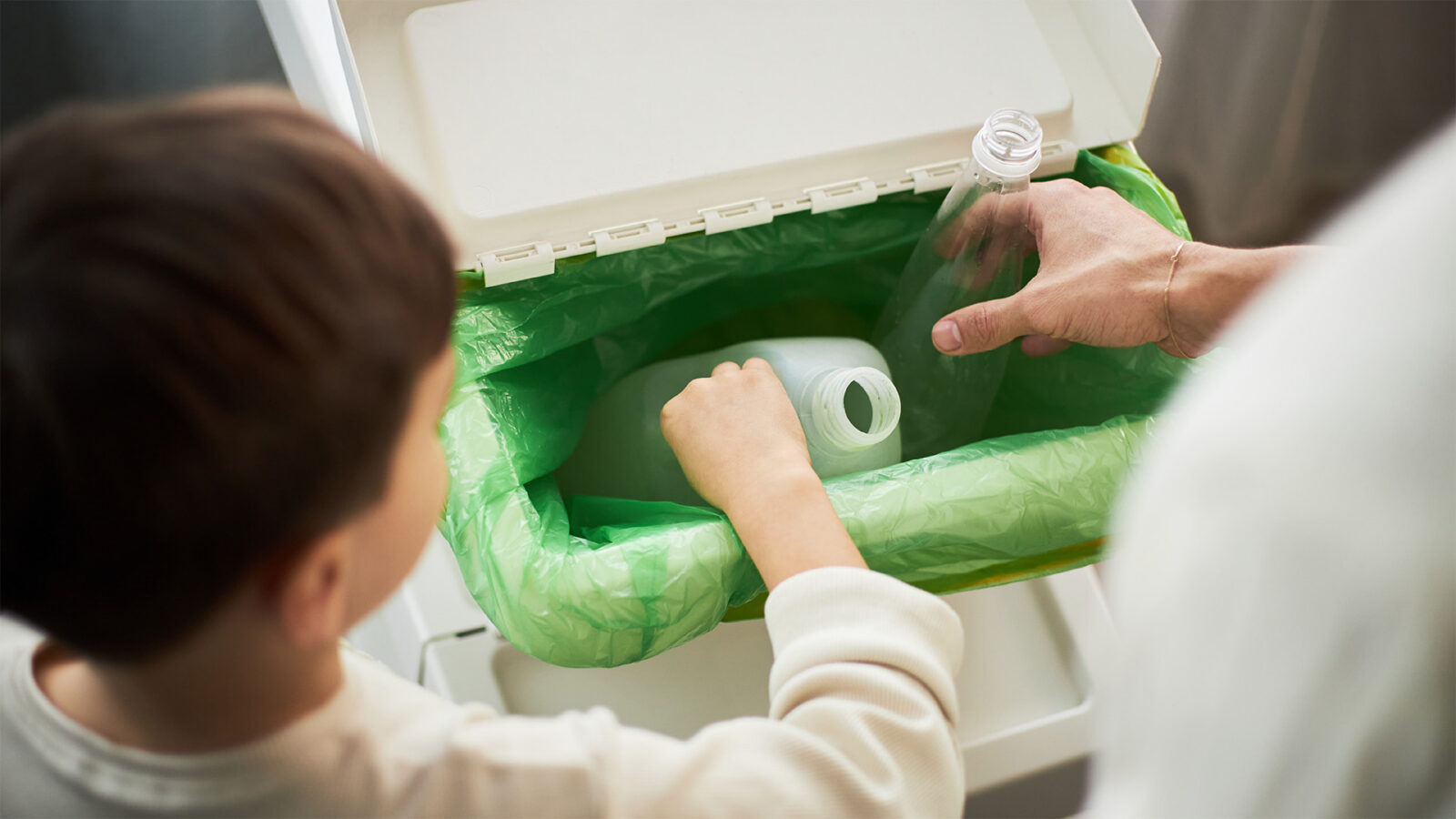 young boy recycling plastic at home