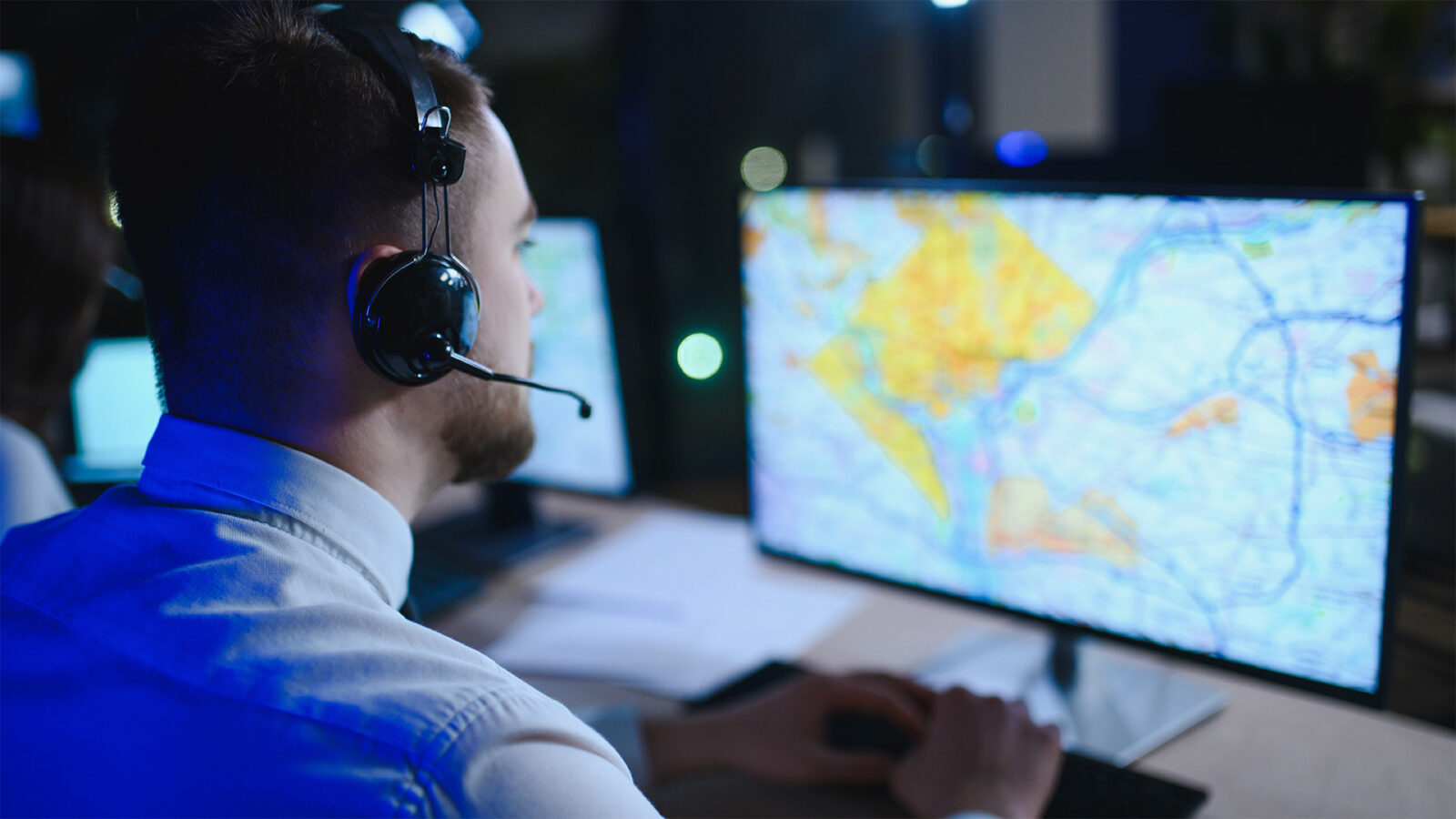 Dispatcher monitoring logistics operations with map on screen