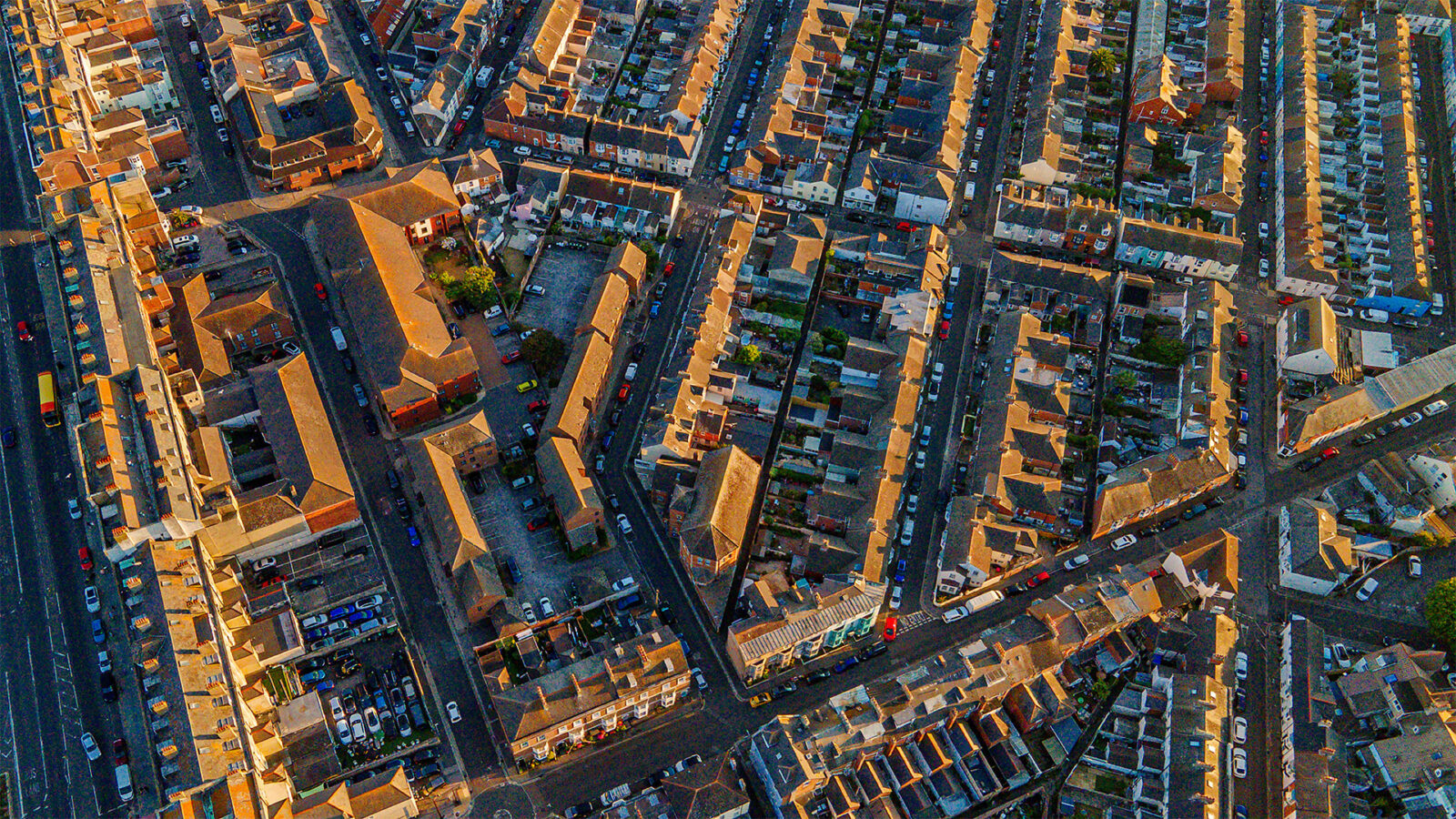 Top down aerial view of coastal town resort streets and buildings at golden hour